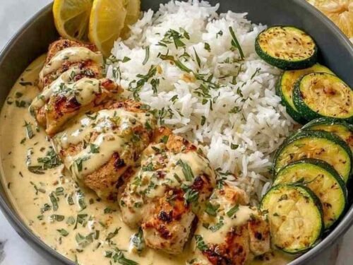 A plated serving of creamy lemon butter chicken drizzled with silky lemon butter sauce, served alongside crispy mozzarella-topped zucchini rounds and fluffy couscous. This is how it turned out in my kitchen on a busy weeknight, golden chicken cutlets with bright citrus flavor that the whole family loved.