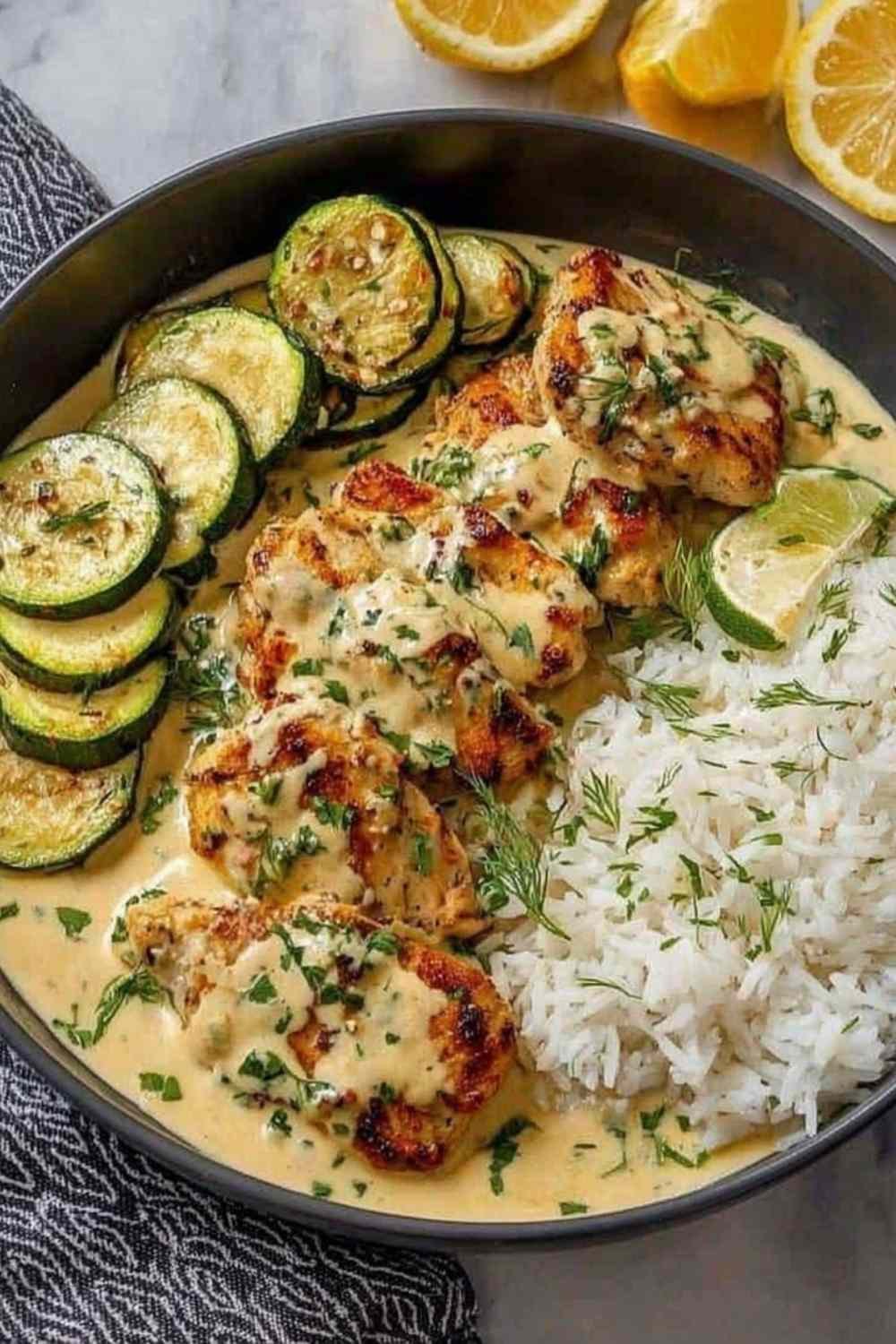 A plated serving of creamy lemon butter chicken drizzled with silky lemon butter sauce, served alongside crispy mozzarella-topped zucchini rounds and fluffy couscous. This is how it turned out in my kitchen on a busy weeknight, golden chicken cutlets with bright citrus flavor that the whole family loved.
